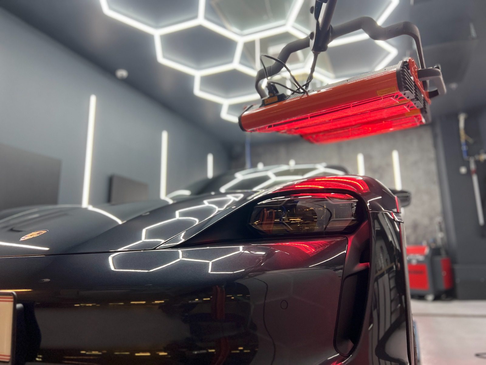 Keramikversiegelung von einem grauen Porsche mit Heizstrahlern über dem Lack